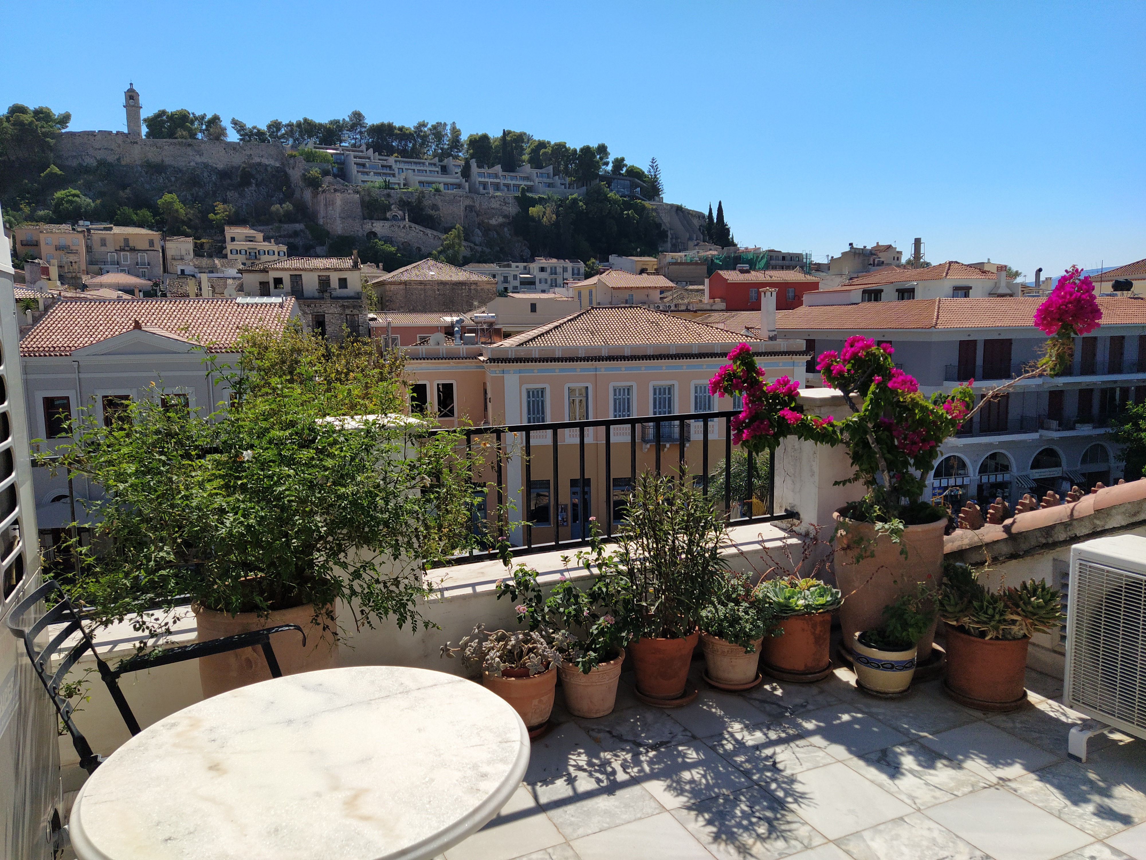 Terrace with several plants and flowers in ceramic pots and a panoramic view