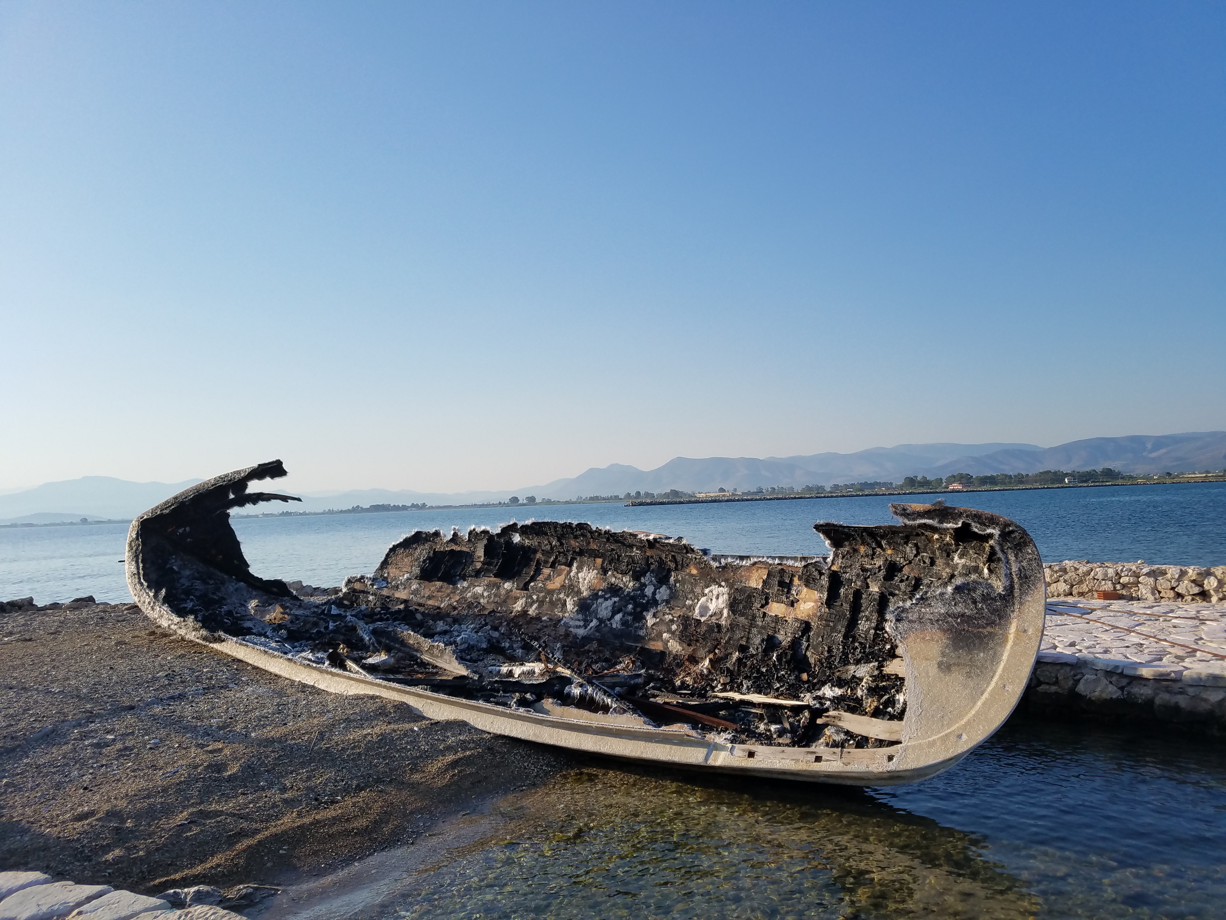 A broken small boat left ashore.