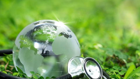 Crystal Earth with a medical doctor's stethoscope on green grass. chayanuphol / Shutterstock