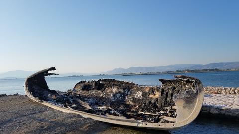 A broken small boat left ashore.