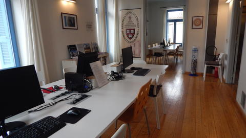 Two long desks with chairs and desktop computers