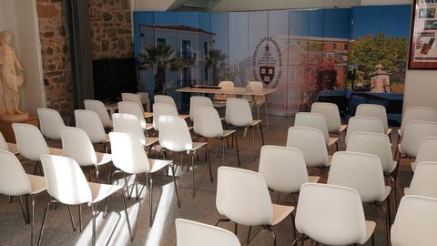 Room with chairs in five rows that face towards a banner