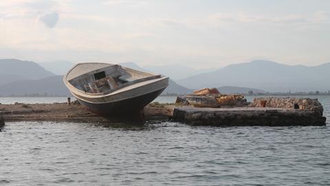 Small boat left ashore in a background full of the blue of the sea and the sky.