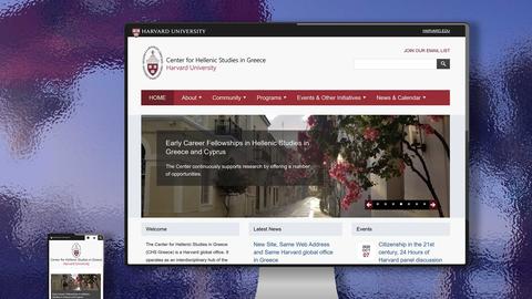 Two different-sized monitors with the CHS Greece website on their screens.