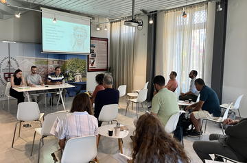 Participants seated in the CHS Greece lecture hall during a session; the projected slide reads "Claudius and Greek culture."