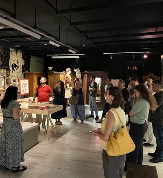 Guided tour of the Ethnological Museum of Nafplio, participants gathered around display cases and traditional costumes.