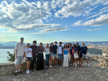 Participants posing at a scenic viewpoint overlooking Nafplio and the surrounding landscape.