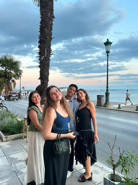 Four participants standing along the Thessaloniki waterfront at sunset.