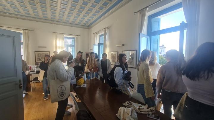 Young women socializing in a relaxed atmosphere of sun-lit room with large windows.