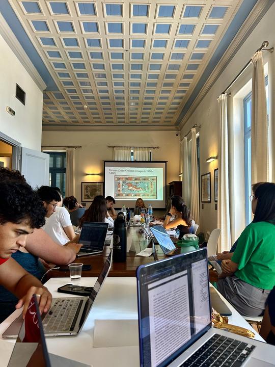 The group during class in an oval-shaped arrangement in the Fellows Room at CHS Greece.