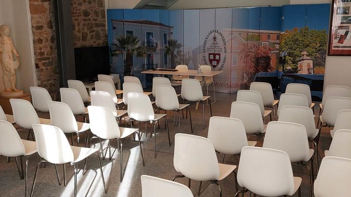 White chairs arranged in order in a conference room.