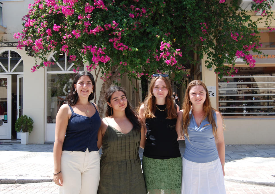 Four young people pose beneath a blooming bougainvillea tree in Nafplio.